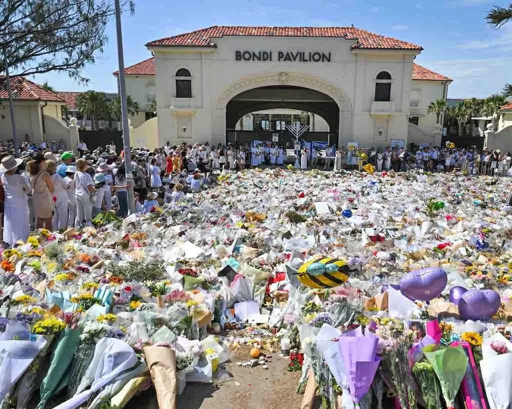 Người dân tham dự buổi lễ tưởng niệm bên bờ biển xung quanh đài tưởng niệm bằng hoa tạm thời tại Bondi Pavilion.