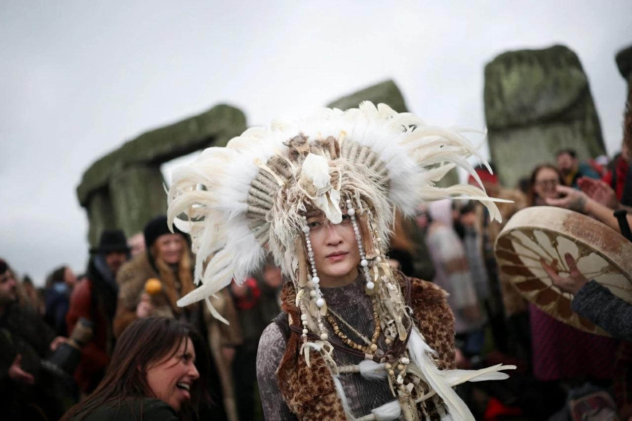 Người dân tham dự lễ đón đông chí tại quần thể đá Stonehenge, gần Amesbury. Đám đông tụ tập trong bóng tối quanh di tích lịch sử ở hạt Wiltshire để ngắm mặt trời mọc, trong đó có người mặc trang phục ngoại giáo truyền thống. (Nguồn: The Guardian)