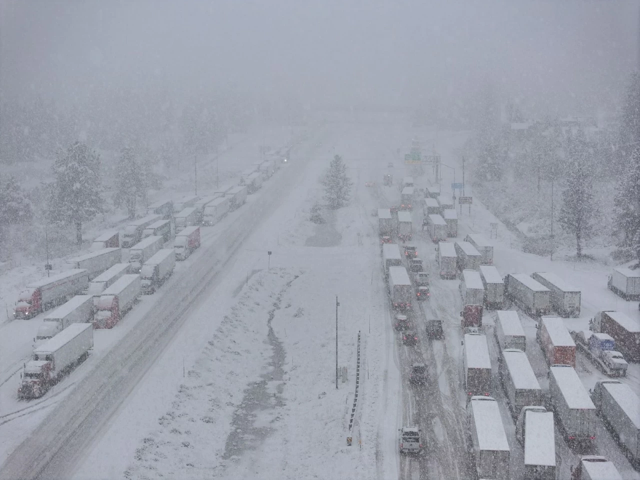 Xe tải ùn ứ trong trận tuyết dày gần đèo Donner, khu vực Truckee. Các trận lở bùn đã vùi lấp ô tô và nhà cửa ngập tới cửa sổ ở bang California, khi một hệ thống bão mạnh gây ra mùa Giáng sinh mưa nhiều nhất trong nhiều thập kỷ tại bang này. (Nguồn: Anadolu)