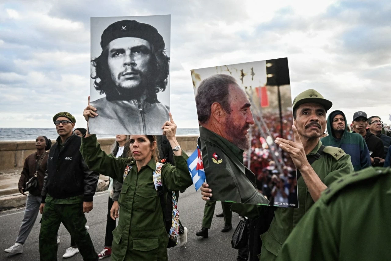Người dân cầm hình ảnh của anh hùng cách mạng Ernesto “Che” Guevara và cố lãnh tụ Cuba Fidel Castro trong một cuộc biểu tình chống chủ nghĩa đế quốc bên ngoài Đại sứ quán Mỹ. Ba mươi hai nhân viên an ninh Cuba đã thiệt mạng trong cuộc đột kích của Mỹ nhằm bắt cóc Nicolás Maduro. Sau chiến dịch quân sự tại Caracas, ông Trump cho rằng Cuba đang “đứng trước nguy cơ sụp đổ”, viện dẫn cuộc khủng hoảng kinh tế nghiêm trọng của hòn đảo và nói rằng Havana sẽ khó có thể “cầm cự” nếu không có nguồn dầu giá rẻ từ Venezuela. (Nguồn: Getty Images)