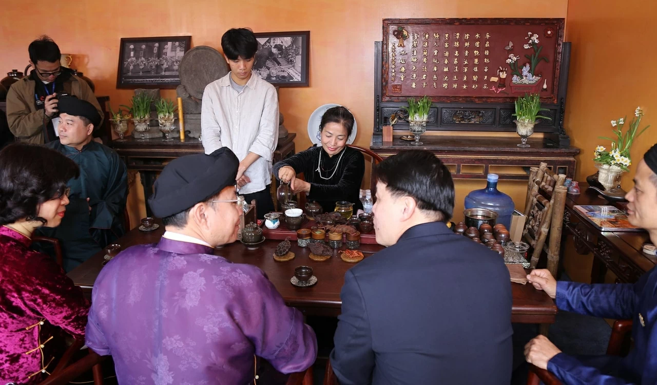 Các đại biểu thưởng thức văn hóa trà và xem tranh Đông hồ. (Ảnh: Thành Long)