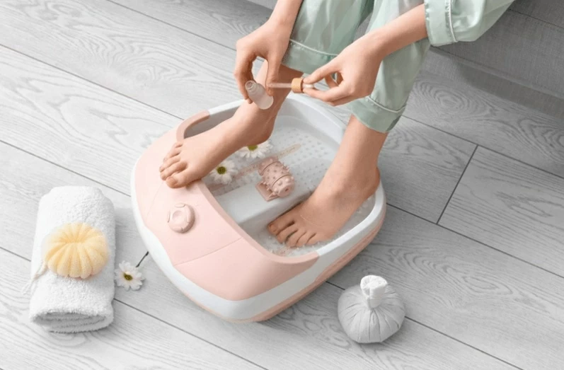 Phụ nữ ngâm chân trong nước ấm buổi tối trước khi hỗ trợ điều hòa thân nhiệt và ngủ sâu hơn