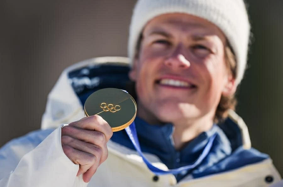 Vận động viên Johannes Hoesflot Klaebo (Na Uy) ăn mừng tấm Huy chương Vàng lịch sử tại lễ trao giải nội dung tiếp sức 4x7,5km nam, Thế vận hội Mùa đông Milan-Cortina 2026, ngày 15/2. (Nguồn: Xinhua)