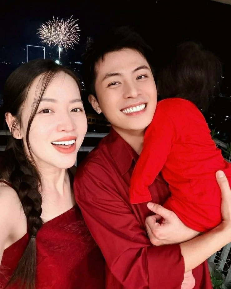 Puka và Gin Tuấn Kiệt bế con gái cùng ngắm pháo hoa đón năm mới. Gia đình cặp sao cùng diện trang phục màu đỏ để lấy may đầu năm. (Nguồn: FBNV)