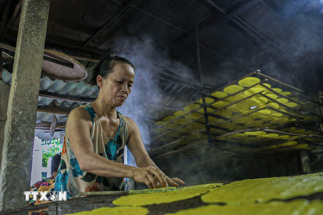 Nghệ nhân cần mẫn làm từng chiếc bánh tráng truyền thống. (Ảnh: Văn Dũng/TTXVN) ttxvn-lang-nghe-banh-trang-luu-bao-2.jpg