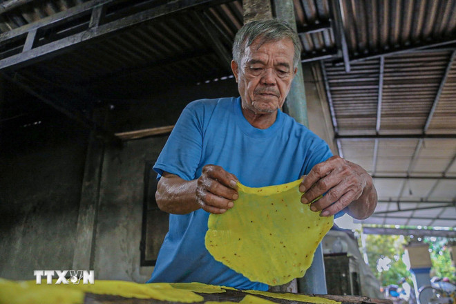 Nghệ nhân cần mẫn làm từng chiếc bánh tráng truyền thống. (Ảnh: Văn Dũng/TTXVN) ttxvn-lang-nghe-banh-trang-luu-bao-3.jpg