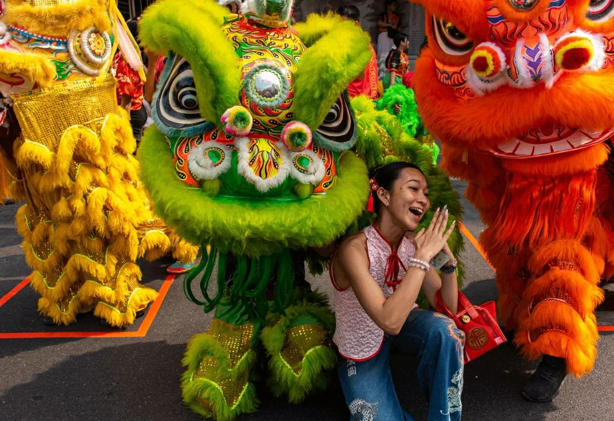 Người dân chụp ảnh cùng các nghệ sĩ múa lân trên phố Tàu, Bangkok, Thái Lan. (Ảnh: Shutterstock)