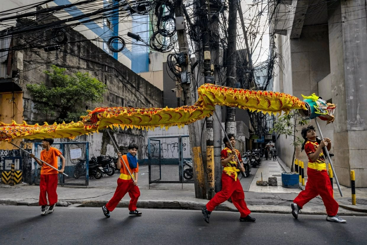 Đoàn múa rồng diễu hành dọc theo một con phố ở quận Binondo - nơi được xem là khu phố Tàu lâu đời nhất thế giới - vào ngày mùng 1 Tết. (Ảnh: Getty Images)