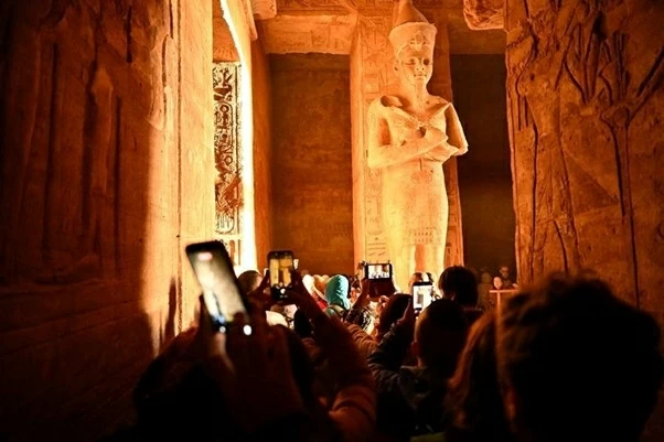 Vào những ngày 22/2 và 22/10 hàng năm, ánh bình minh sẽ chiếu thẳng qua lối vào đền, xuyên qua hành lang dài 60m để soi sáng các bức tượng thần trong buồng tối linh thiêng nhất. Hiện tượng này thu hút hàng nghìn du khách xếp hàng từ sáng sớm để chứng kiến. (Ảnh: Xinhua)