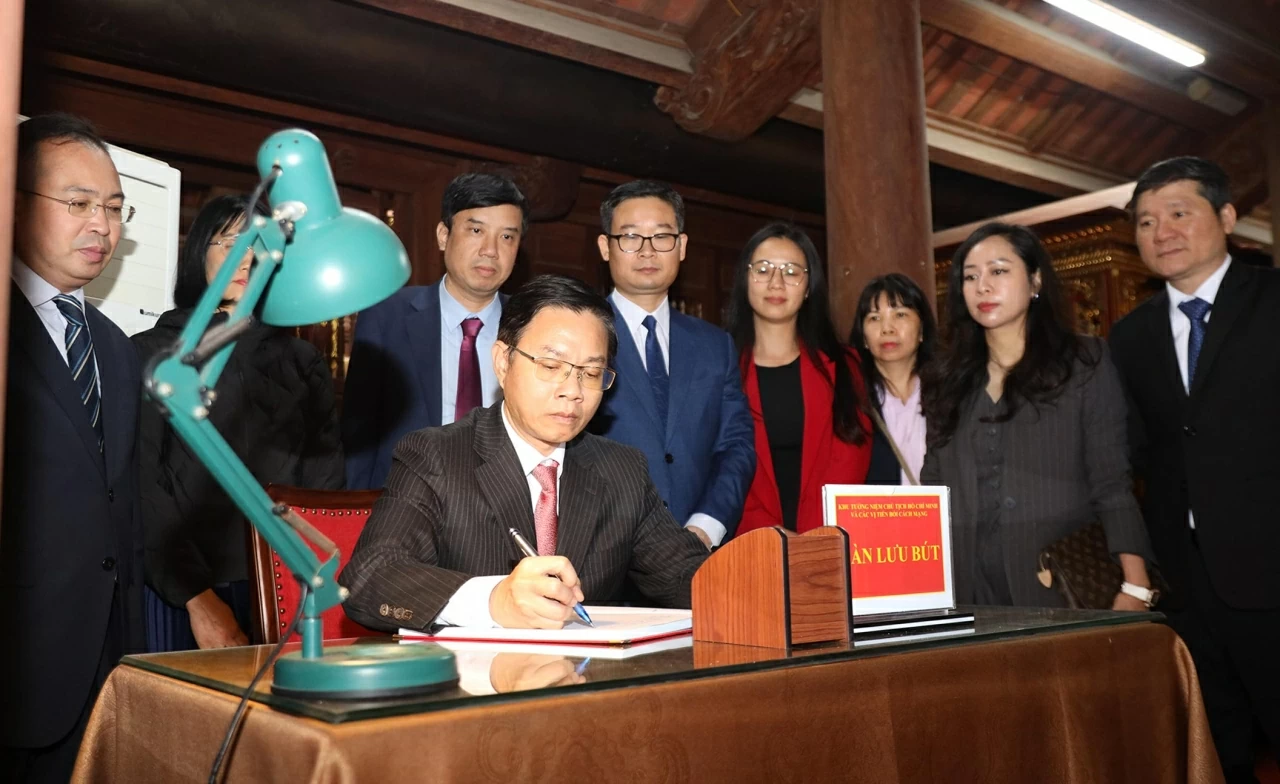 Thứ trưởng Ngoại giao Ngô Lê Văn viết lưu bút tại Khu tưởng niệm Chủ tịch Hồ Chí Minh và các chiến sĩ. (Ảnh: Thành Long)