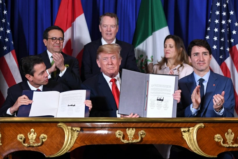 Theo phóng viên TTXVN tại Mexico, AmCham Mexico nhận định trong bối cảnh địa chính trị toàn cầu ngày phức tạp, khu vực Bắc Mỹ có lợi thế về quy mô thị trường, tính ổn định của khung pháp lý và khả năng phục hồi của chuỗi cung ứng. Đây là những yếu tố then chốt để duy trì tăng trưởng dài hạn. Hiệp hội doanh nghiệp do ông Carlos García đứng đầu nhận định việc rà soát USMCA dự kiến diễn ra trong năm 2026 là cơ hội để cập nhật cơ chế hợp tác phù hợp với nhu cầu mới của Mexico, Mỹ và Canada.  Quá trình rà soát hiệp định vào tháng 7/2026 có thể giúp củng cố các thành tựu các bên đã đạt được, bao gồm điều chỉnh quy tắc xuất xứ, bổ sung những lĩnh vực mới như bán dẫn và trí tuệ nhân tạo, đồng thời tăng cường các cơ chế bảo đảm thực thi cam kết giữa những nước thành viên. AmCham cho biết trong quá trình rà soát, các nước có thể quyết định gia hạn hiệu lực của hiệp định thêm 16 năm, đến năm 2042, hoặc chuyển sang cơ chế đánh giá hằng năm. Số liệu của hiệp hội doanh nghiệp này cho thấy khu vực Bắc Mỹ hiện có hơn 500 triệu người tiêu dùng và đóng góp gần 30% Tổng sản phẩm quốc nội (GDP) toàn cầu.  Mỗi giờ có hơn 100 triệu USD giá trị thương mại được trao đổi qua biên giới giữa Mexico và Mỹ, tương đương hơn 500.000 xe tải và khoảng 1 triệu lượt người qua lại mỗi ngày. Ngoài ra, hơn 40% giá trị hàng xuất khẩu của Mexico sang Mỹ có chứa hàm lượng sản xuất từ Mỹ, cho thấy mức độ liên kết sâu sắc của chuỗi giá trị trong khu vực. Theo AmCham, trong nhiều trường hợp, các doanh nghiệp có thể đưa một sản phẩm qua lại biên giới tới 8 lần trong quá trình sản xuất, qua đó tạo thêm giá trị ở cả hai phía. Từ năm 2023, Mexico trở thành đối tác thương mại lớn nhất của Mỹ, đồng thời đến năm 2025 cũng là thị trường xuất khẩu và nguồn cung hàng hóa hàng đầu của Mỹ. AmCham Mexico khẳng định sẵn sàng tiếp tục đóng vai trò cầu nối hợp tác giữa doanh nghiệp hai nước, đồng thời chia sẻ thông tin từ cộng đồng doanh nghiệp nhằm hỗ trợ quá trình hoạch định chính sách. (Nguồn: AFP)