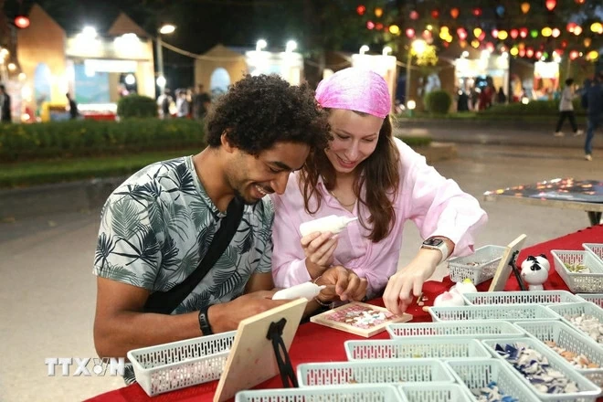 Du khách trải nghiệm văn hóa thưởng trà truyền thống trong không gian thanh tịnh được bài trí đậm chất nghệ thuật tại lễ hội. (Nguồn: TTXVN)