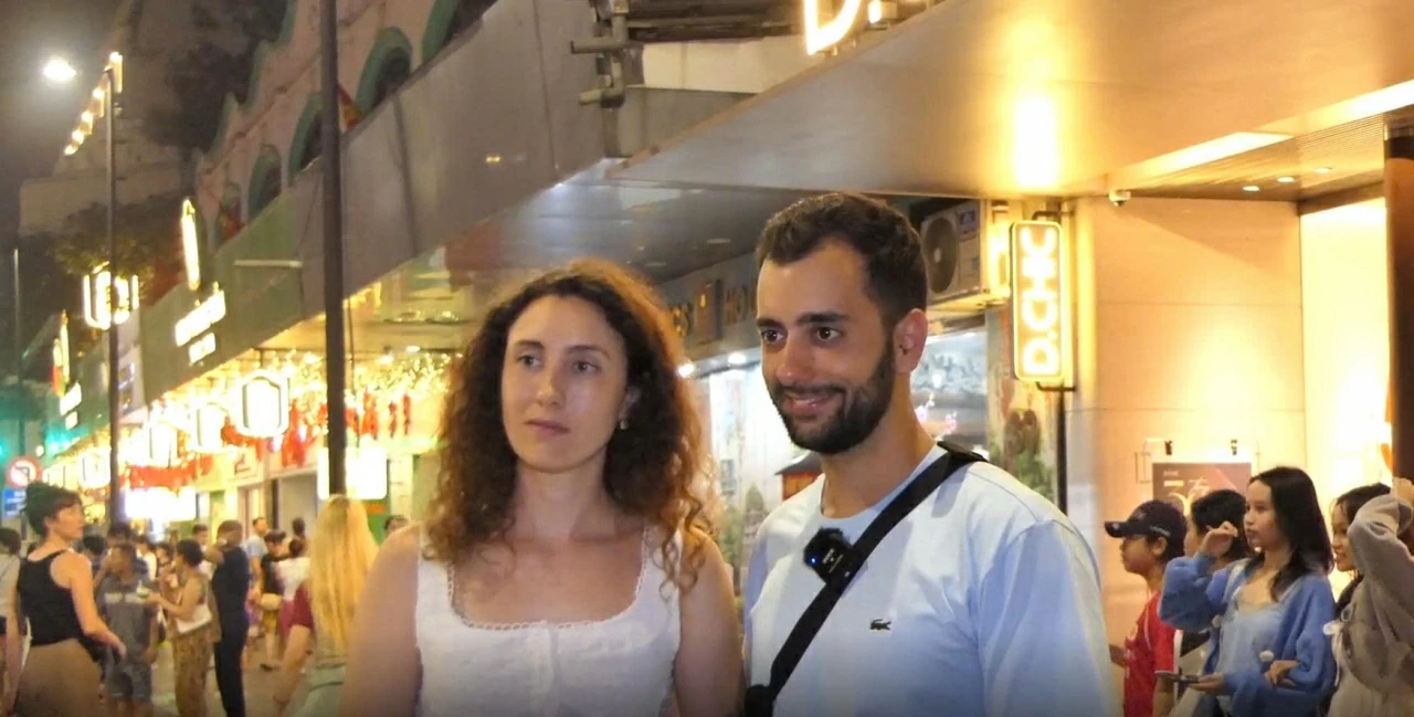 Hai du khách Tây Ban Nha coi trải nghiệm chợ đêm Hà Nội là hoạt động thú vị nhất ở thủ đô ban đêm. (Ảnh: Liên Thanh)