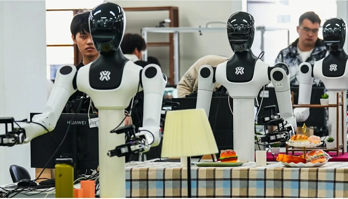 Các công nhân đang huấn luyện robot hình người. Hình ảnh được ghi lại tại trung tâm đào tạo robot của X-Humanoid ở ngoại ô Bắc Kinh ngày 19/3. Ảnh: Justin Robertson/CNN.