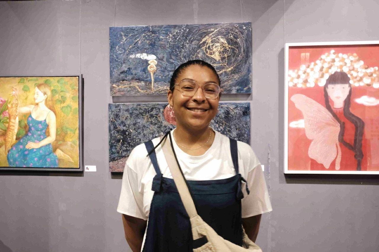 Cassandre (Pháp) trải nghiệm không gian nghệ thuật tại triển lãm “Phụ nữ vẽ Phụ nữ”. (Ảnh: Diệu Hoa)