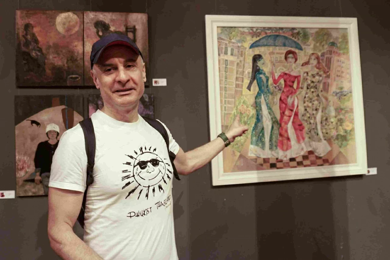 Du khách Alparslan (Thổ Nhĩ Kỳ) bên tác phẩm “Ba cô nàng Sài Gòn đỏng đảnh”. (Ảnh: Minh Hằng)