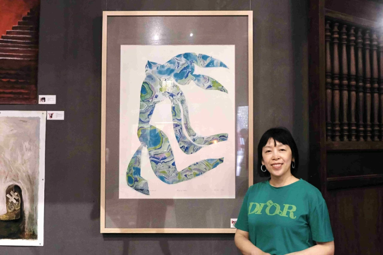 Họa sĩ Lê Thị Thanh với tác phẩm “Nhớ về các Master” tại triển lãm. (Ảnh: Hà Anh)