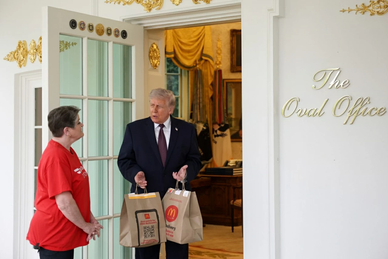Tổng thống Mỹ Donald Trump nhận một đơn giao hàng từ Sharon Simmons của DoorDash bên ngoài Phòng Bầu dục tại Nhà Trắng vào thứ Hai, ngày 13 tháng 4. Đơn hàng McDonald's này là một phần của hoạt động dàn dựng nhằm chụp ảnh quảng bá cho chính sách “không đánh thuế tiền tip” của ông Trump trước ngày khai thuế. (Nguồn: Getty Images)
