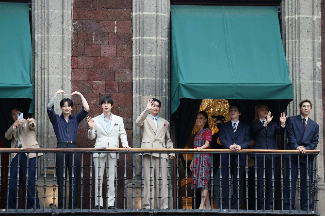 Tổng thống Mexico Claudia Sheinbaum cùng nhóm nhạc K-pop Hàn Quốc BTS vẫy chào người hâm mộ từ ban công tại Quảng trường Zócalo, thành phố Mexico. (Nguồn: Yonhap)