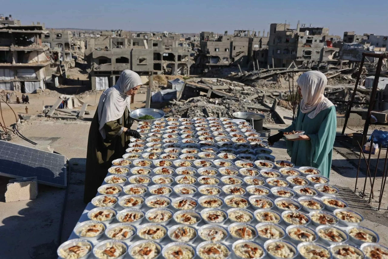 Hai chị em người Palestine Lina và Aya Zeid chuẩn bị các suất ăn trên mái nhà để phân phát cho trẻ em phải sơ tán ở phía bắc Dải Gaza. (Nguồn: Getty Images)