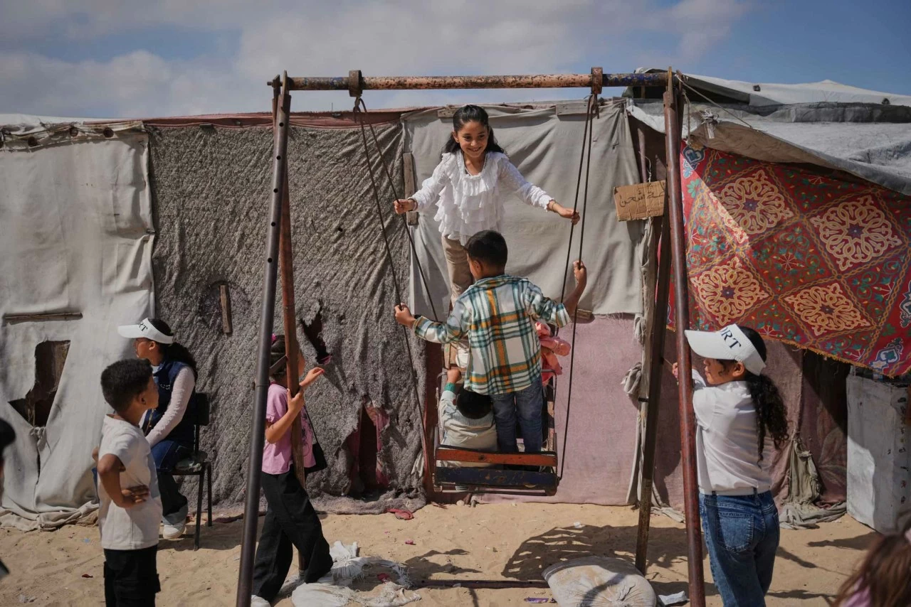 Những trẻ em Palestine phải di dời khỏi nhà cửa vui chơi trên chiếc xích đu tại một khu lều tạm ở Gaza trong dịp Eid al-Adha. (Nguồn: X) Những trẻ em Palestine phải di dời khỏi nhà cửa vui chơi trên chiếc xích đu tại một khu lều tạm ở Gaza trong dịp Eid al-Adha. (Nguồn: X)