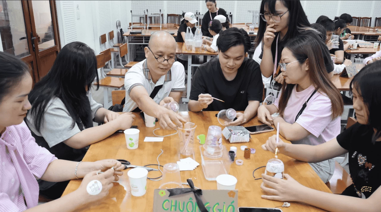 Khách mời tái chế cốc nhựa thành chuông gió trang trí. (Ảnh: Phương Anh)