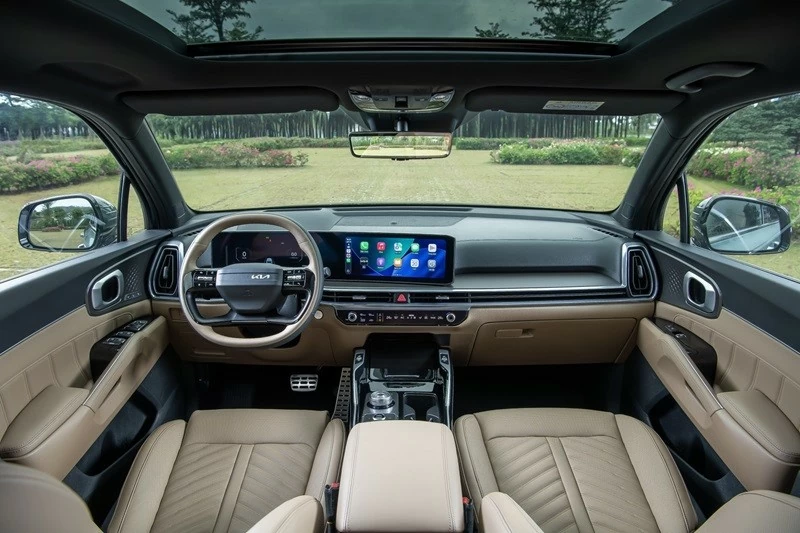 Khoang lái của Kia Sorento Hybrid 2026 được làm mới với vô-lăng hai chấu đáy phẳng cùng cụm màn hình cong đặt nổi trên táp-lô. Khoang lái của Kia Sorento Hybrid 2026 được làm mới với vô-lăng hai chấu đáy phẳng cùng cụm màn hình cong đặt nổi trên táp-lô.