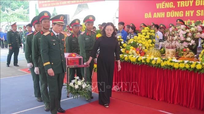 Các đại biểu cùng nhân dân thực hiện nghi thức di quan, tiễn đưa 9 hài cốt liệt sĩ về nơi an nghỉ cuối cùng tại Nghĩa trang liệt sĩ Bản Qua, Bát Xát. (Nguồn: TTXVN)