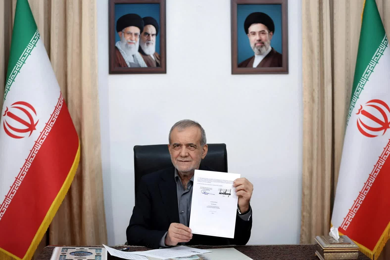 Tổng thống Iran Masoud Pezeshkian giơ bản thỏa thuận với Mỹ sau khi ký tại Tehran, Iran, ngày 18/6. Sau lễ ký, ông Pezeshkian viết trên mạng xã hội X: “Đây là một văn kiện mang tính lịch sử và là thông điệp từ một nước Iran hùng mạnh: hòa bình sẽ chỉ đạt được trên cơ sở tôn trọng lẫn nhau.” (Nguồn: WANA) Tổng thống Iran Masoud Pezeshkian giơ bản thỏa thuận với Mỹ sau khi ký tại Tehran, Iran, ngày 18/6. Sau lễ ký, ông Pezeshkian viết trên mạng xã hội X: “Đây là một văn kiện mang tính lịch sử và là thông điệp từ một nước Iran hùng mạnh: hòa bình sẽ chỉ đạt được trên cơ sở tôn trọng lẫn nhau.” (Nguồn: WANA)