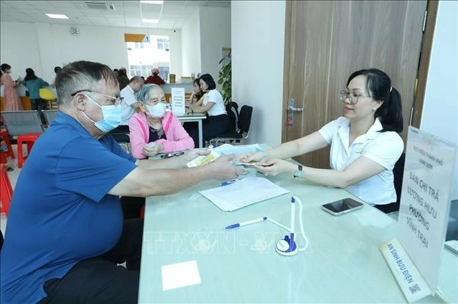 Cán bộ nhân viên Bưu điện chi trả lương hưu cho người dân. (Nguồn: TTXVN)