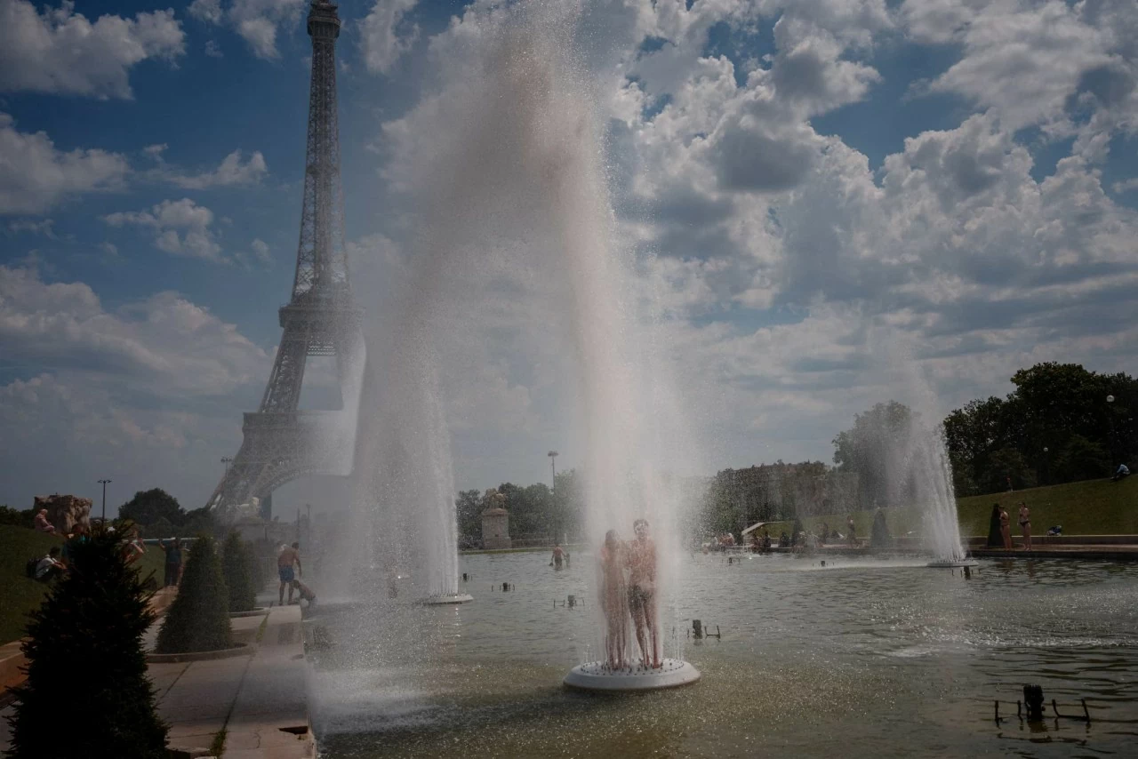 Một cặp đôi giải nhiệt tại đài phun nước Trocadéro Gardens trong đợt nắng nóng ở Paris. Số người thiệt mạng tại France liên quan đến đợt nắng nóng đã tăng lên bốn trẻ nhỏ, trong khi hơn 55 người tử vong do đuối nước. Các nhà dự báo cho biết đợt nắng nóng khắc nghiệt đang quét qua châu Âu sẽ tiếp tục dịch chuyển về phía Đông, khiến khoảng 150 triệu người phải hứng chịu nền nhiệt lên tới 35°C. (Nguồn: The Guardian)
