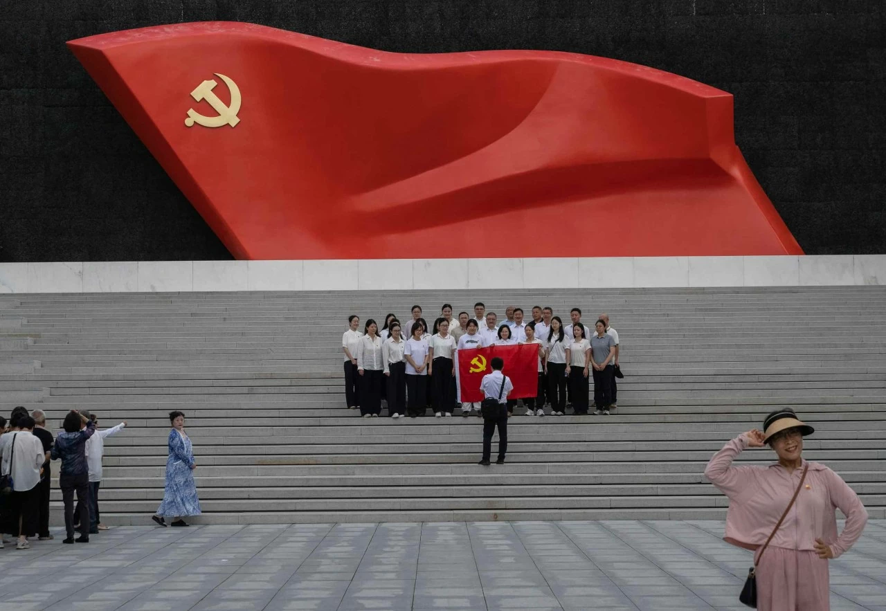 Người dân chụp ảnh trước lá cờ lớn của Communist Party of China nhân dịp kỷ niệm 105 năm ngày thành lập tổ chức này tại Beijing. (Nguồn: Getty Images)