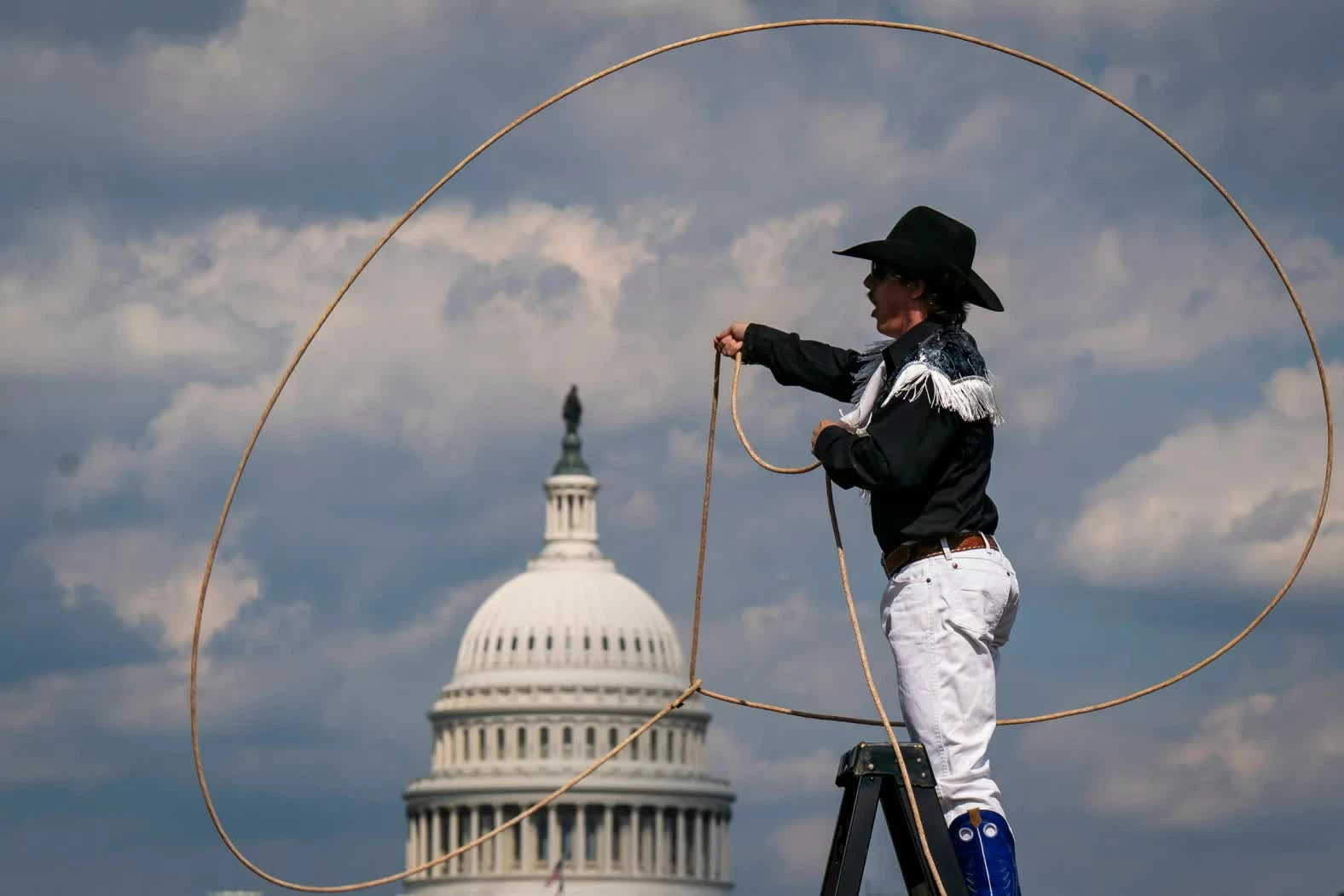 Một nghệ sĩ biểu diễn xoay dây thòng lọng trong khuôn khổ Great American State Fair tại Washington vào thứ Năm, 25/6. Hội chợ, được tổ chức nhằm kỷ niệm 250 năm lập quốc của nước Mỹ, diễn ra tại National Mall và kéo dài đến ngày 10/7. (Nguồn: Bloomberg)