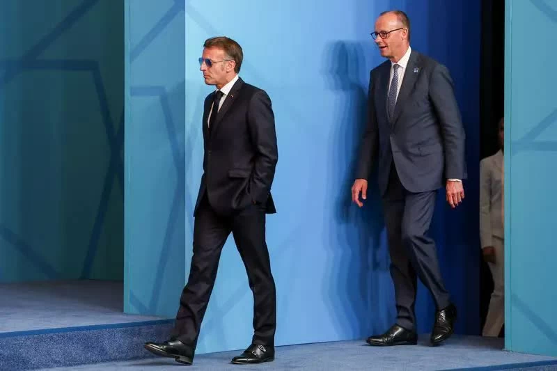 Tổng thống Emmanuel Macron bước vào Hội nghị cùng Thủ tướng Đức Friedrich Merz. (Nguồn: The Star)