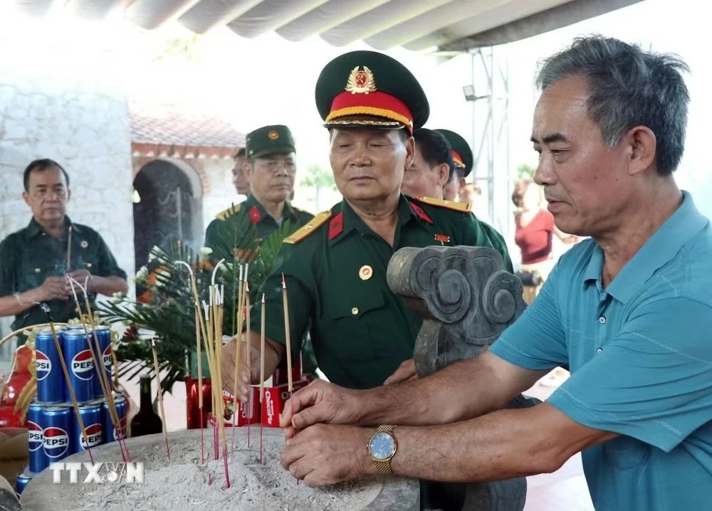 Các cựu chiến binh trở lại Điểm cao 468, tự hào dưới lá cờ Tổ quốc trên chiến trường xưa. (Nguồn: TTXVN)
