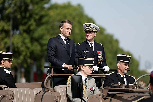 Tổng thống Pháp Emmanuel Macron (giữa) duyệt binh trên xe chỉ huy cùng Tham mưu trưởng Liên quân Fabien Mandon (giữa, phải) tại đại lộ Champs-Élysées. (Nguồn: Getty Images)