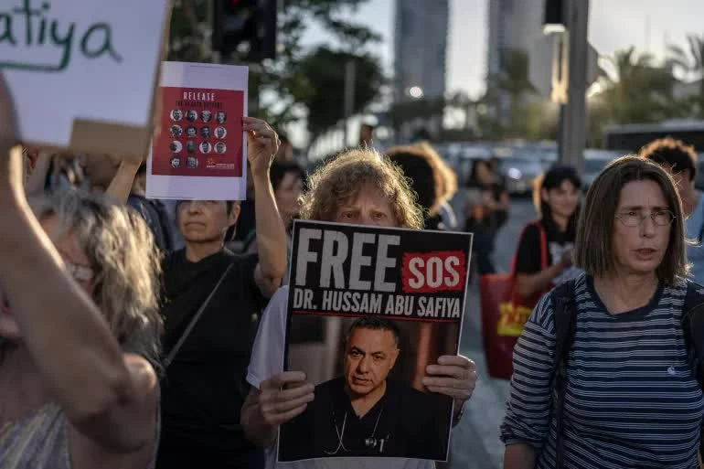 Người biểu tình tại Tel Aviv kêu gọi trả tự do cho bác sĩ Hussam Abu Safia, Giám đốc Bệnh viện Kamal Adwan ở phía Bắc Dải Gaza, đang bị Israel giam giữ. (Nguồn: Al Jazeera) Người biểu tình tại Tel Aviv kêu gọi trả tự do cho bác sĩ Hussam Abu Safia, Giám đốc Bệnh viện Kamal Adwan ở phía Bắc Dải Gaza, đang bị Israel giam giữ. (Nguồn: Al Jazeera)