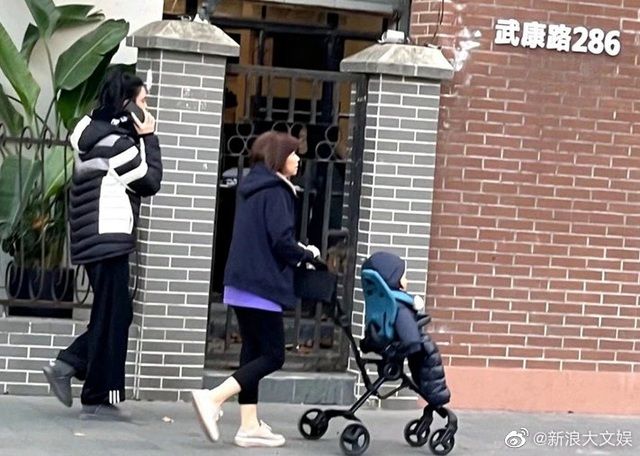 Hề Mộng Dao cùng bảo mẫu đẩy con trai Hà Quảng Sân đi dạo phố ở Thượng Hải. 