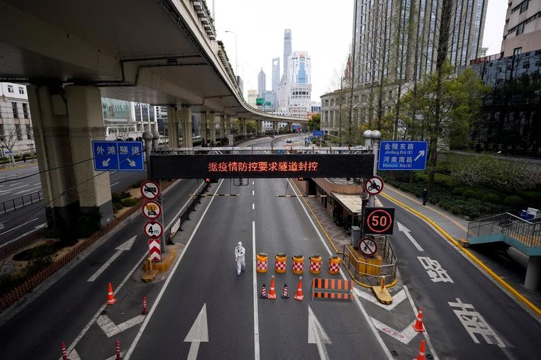 Một công nhân trong bộ đồ bảo hộ đi bộ tại lối vào một đường hầm dẫn đến khu vực Phố Đông bên kia sông Hoàng Phố, sau khi hạn chế giao thông trên đường cao tốc trong bối cảnh khóa cửa để ngăn chặn sự lây lan của coronavirus ở Thượng Hải, Trung Quốc, ngày 