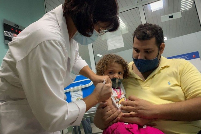 Anh Pedro Montano bế con gái Roxana, 3 tuổi, khi cô bé được tiêm vắc xin Soberana Plus hôm 24/8 trong khuôn khổ một cuộc thử nghiệm ở Havana, Cuba (Ảnh: AFP). 