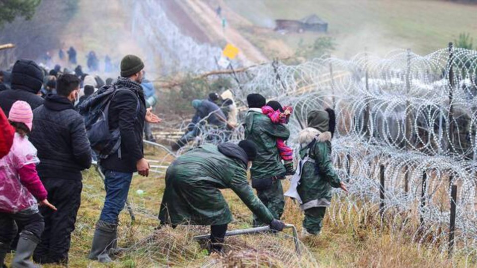 Người di cư trước hàng rào ngăn biên giới Belarus với Ba Lan. Ảnh: AFP