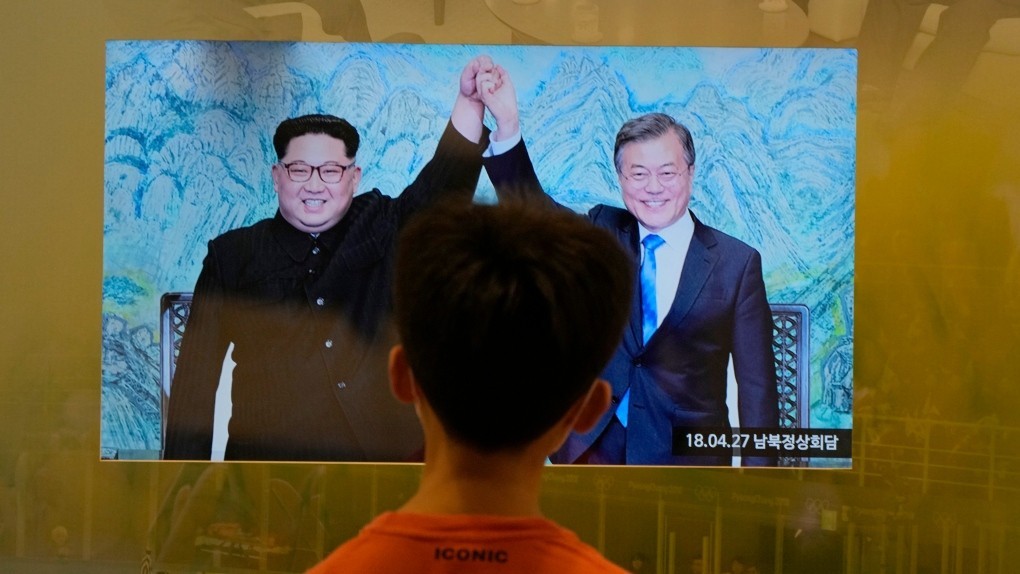 Một cậu bé xem màn hình hiển thị bức ảnh từ hội nghị thượng đỉnh liên Triều ngày 27 tháng 4 năm 2018 giữa Tổng thống Hàn Quốc Moon Jae-in và nhà lãnh đạo Triều Tiên Kim Jong Un, bên trái, tại Trạm quan sát Thống nhất ở Paju, Hàn Quốc, gần biên giới với Triều Tiên, Thứ Hai, ngày 4 tháng 10 năm 2021. (Ảnh AP / Ahn Young-joon)