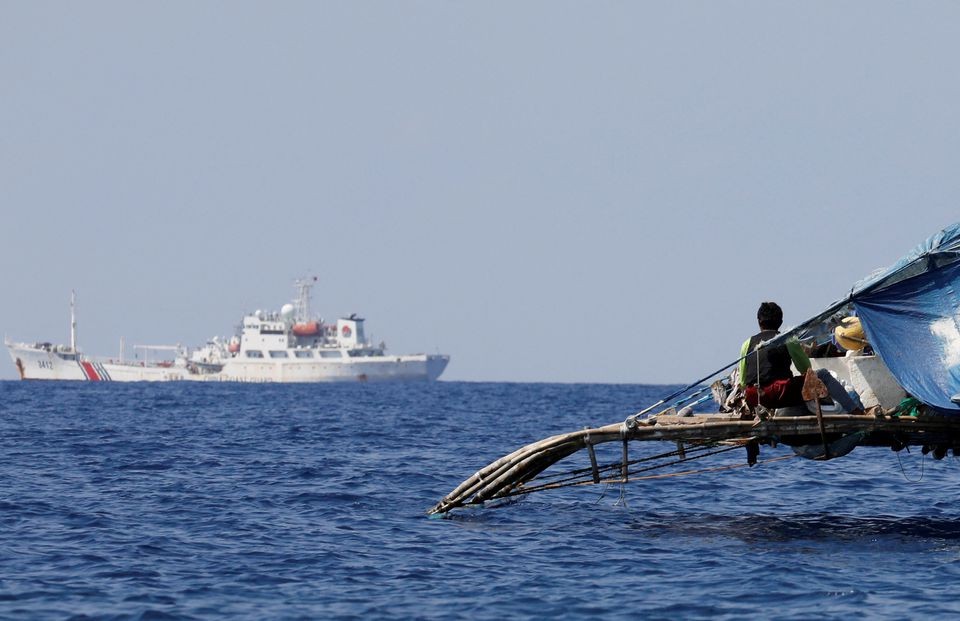 Một ngư dân Philippines theo dõi  tàu Cảnh sát biển Trung Quốc tuần tra tại bãi cạn Scarborough đang tranh chấp trên Biển đông. (Nguồn: Reuters)