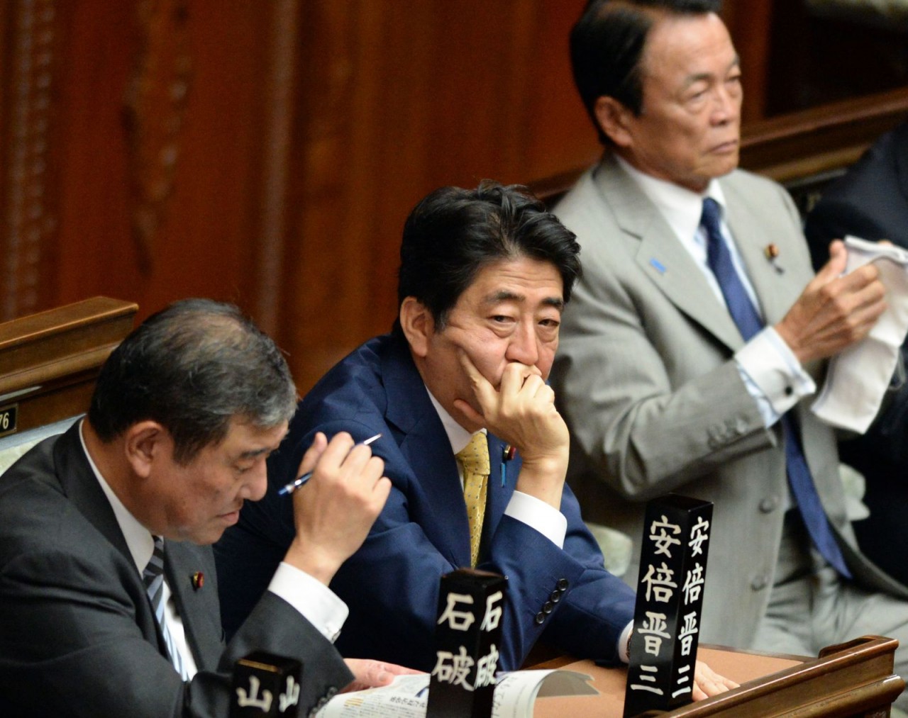 Thủ tướng Abe lắng nghe tuyên bố của các nhà lập pháp đối lập tại Tokyo vào năm 2015. Liên minh cầm quyền của Nhật Bản thông qua một loạt dự luật an ninh gây tranh cãi, đánh dấu sự đảo lộn quan trọng nhất của thế trận quốc phòng 