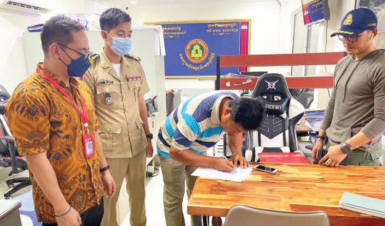 Một nạn nhân của một đường dây buôn người viết bản tường trình tại đồn cảnh sát ở tỉnh Svay Rieng sau khi được giải cứu vào tháng 6/2022. (Nguồn: Khmer Times)