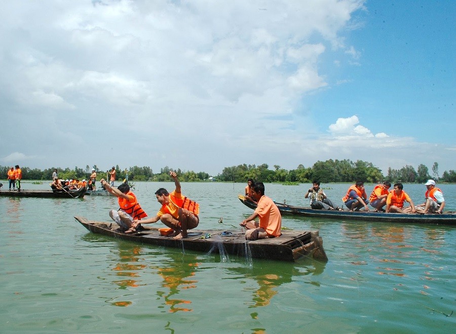Du khách tham gia đánh bắt thủy sản mùa nước nổi trên búng Bình Thiên.