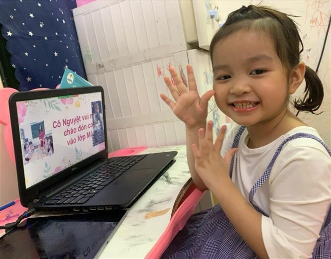 Học sinh lớp 1 Trường tiểu học Thăng Long, quận Hoàn Kiếm vui vẻ, hào hứng được gặp cô giáo chủ nhiệm và các bạn trong buổi tựu trường trực tuyến. (Nguồn: TTXVN)