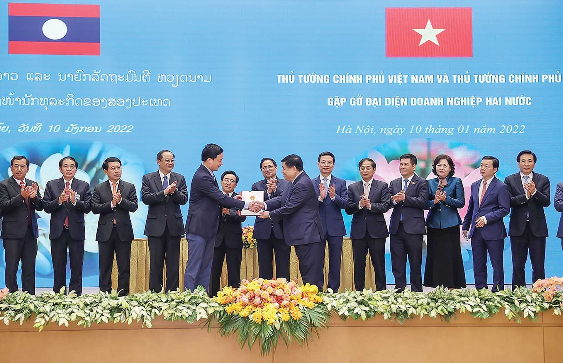 Thủ tướng Phạm Minh Chính và Thủ tướng Lào Phankham Viphavanh cùng các đại biểu tại buổi gặp gỡ doanh nghiệp hai nước. (Nguồn: TTXVN)