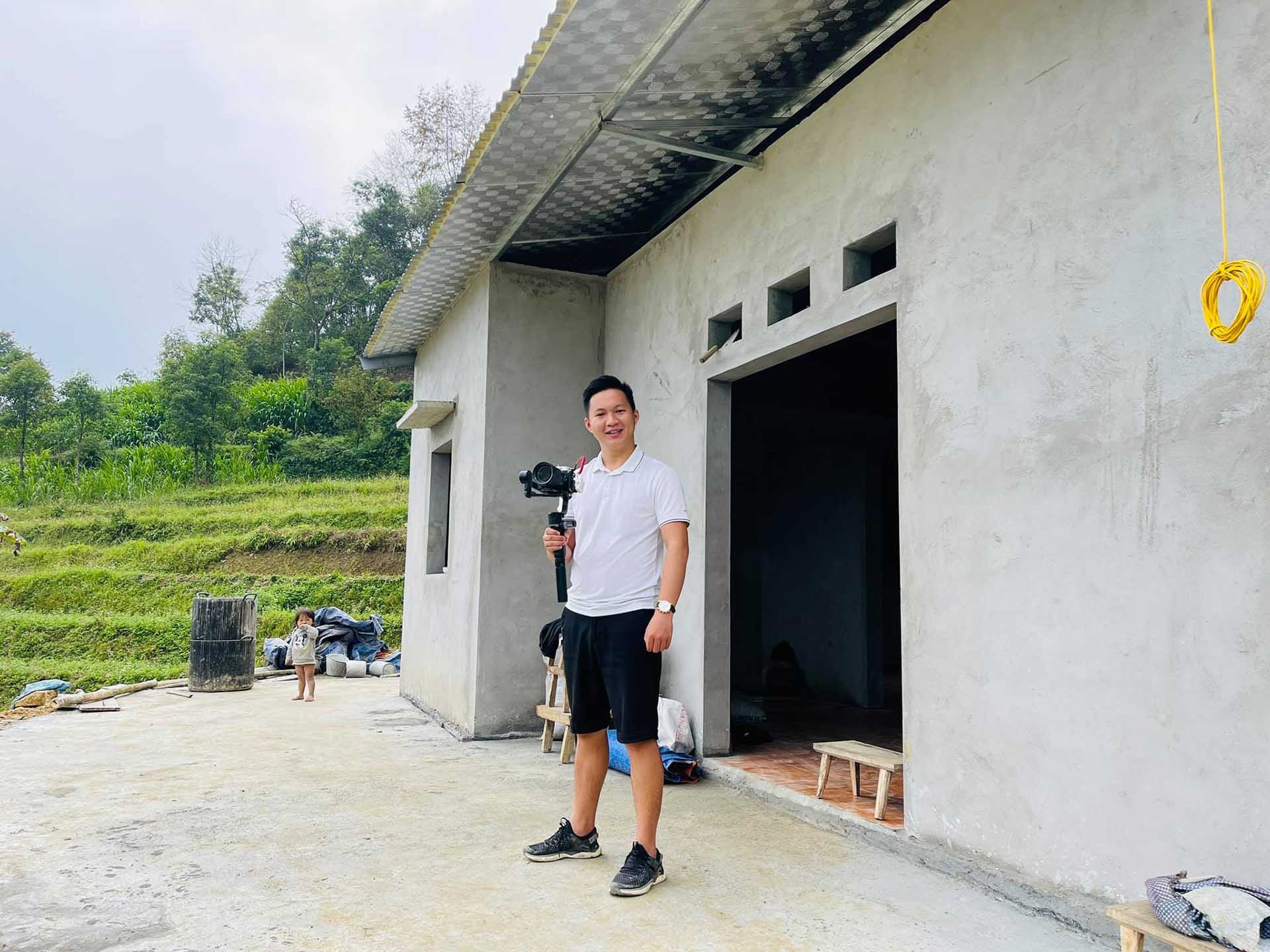 Thầy giáo trẻ Hà Xuân Hiệp trước một ngôi nhà mới được xây cho bà con vùng cao. (Nguồn: NVCC)
