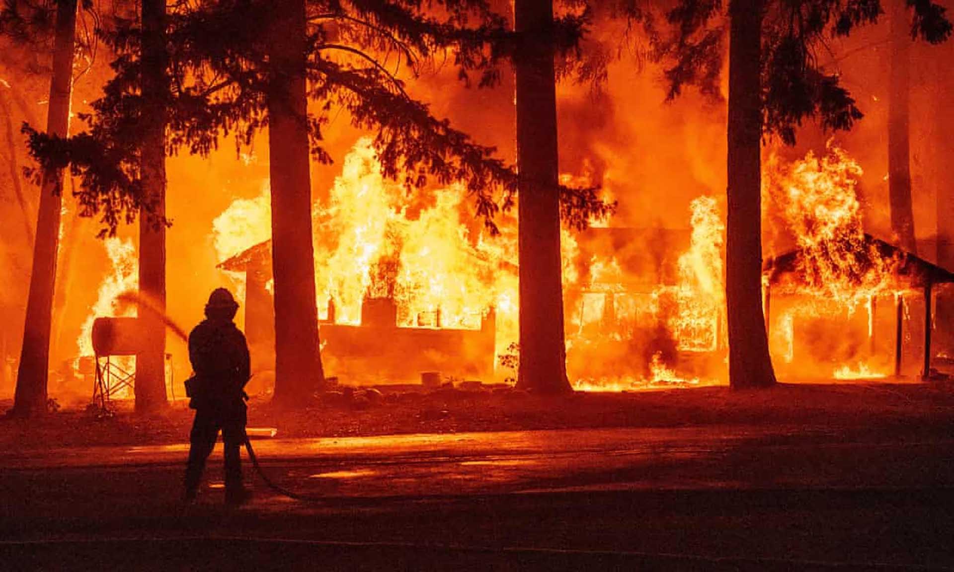 Lính cứu hỏa phun nước dập lửa trong trận cháy rừng Dixie tại hạt  Plumas, California. (Nguồn: AFP)